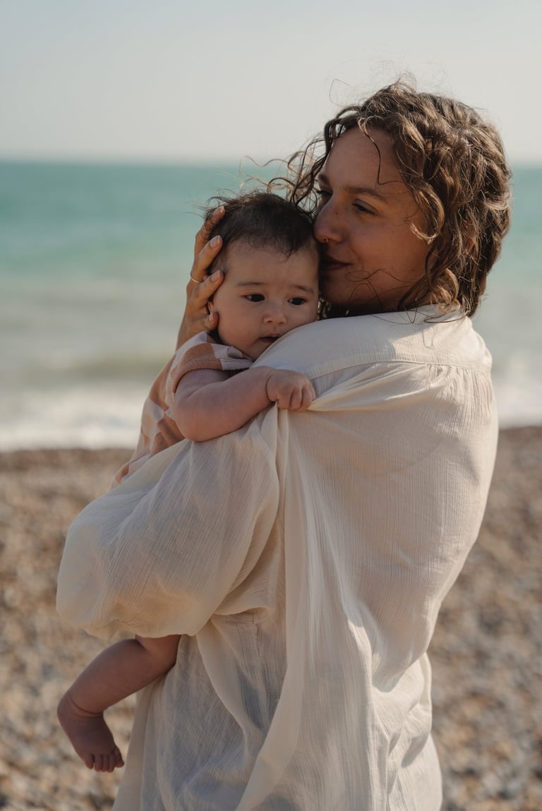 woman holding baby by the sea