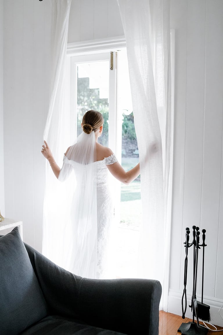 a woman in a white dress is standing in front of a couch
