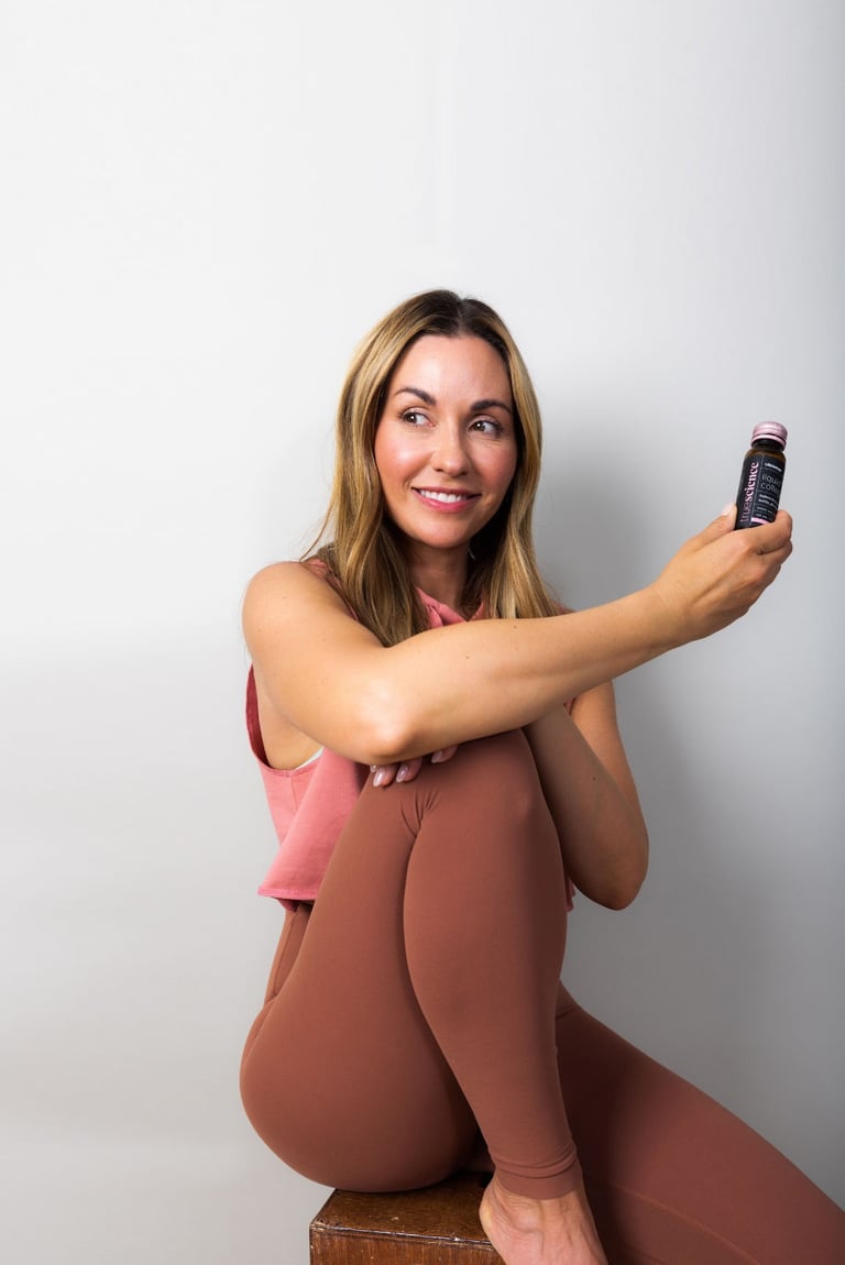 woman-on-wooden-chair-holding-truescience-liquid-collagen