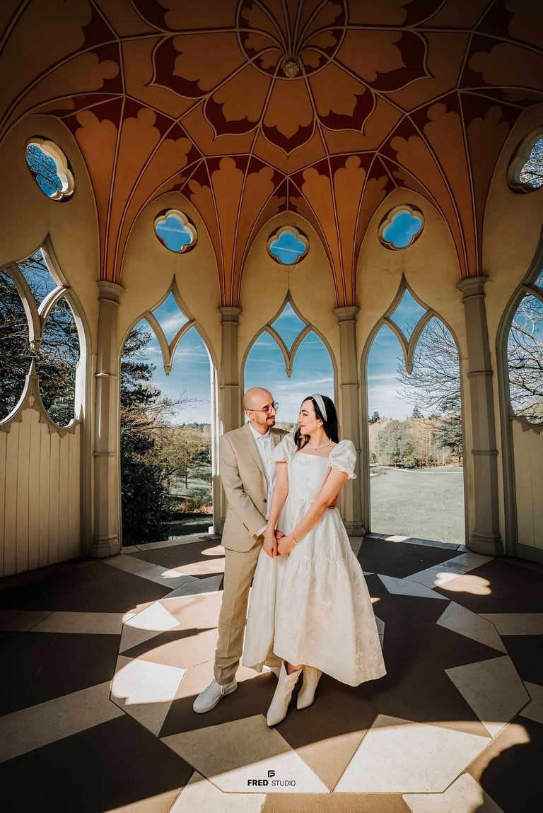 Couple holding hands inside an ornate pavilion in Park, captured by Fred Art Studio.