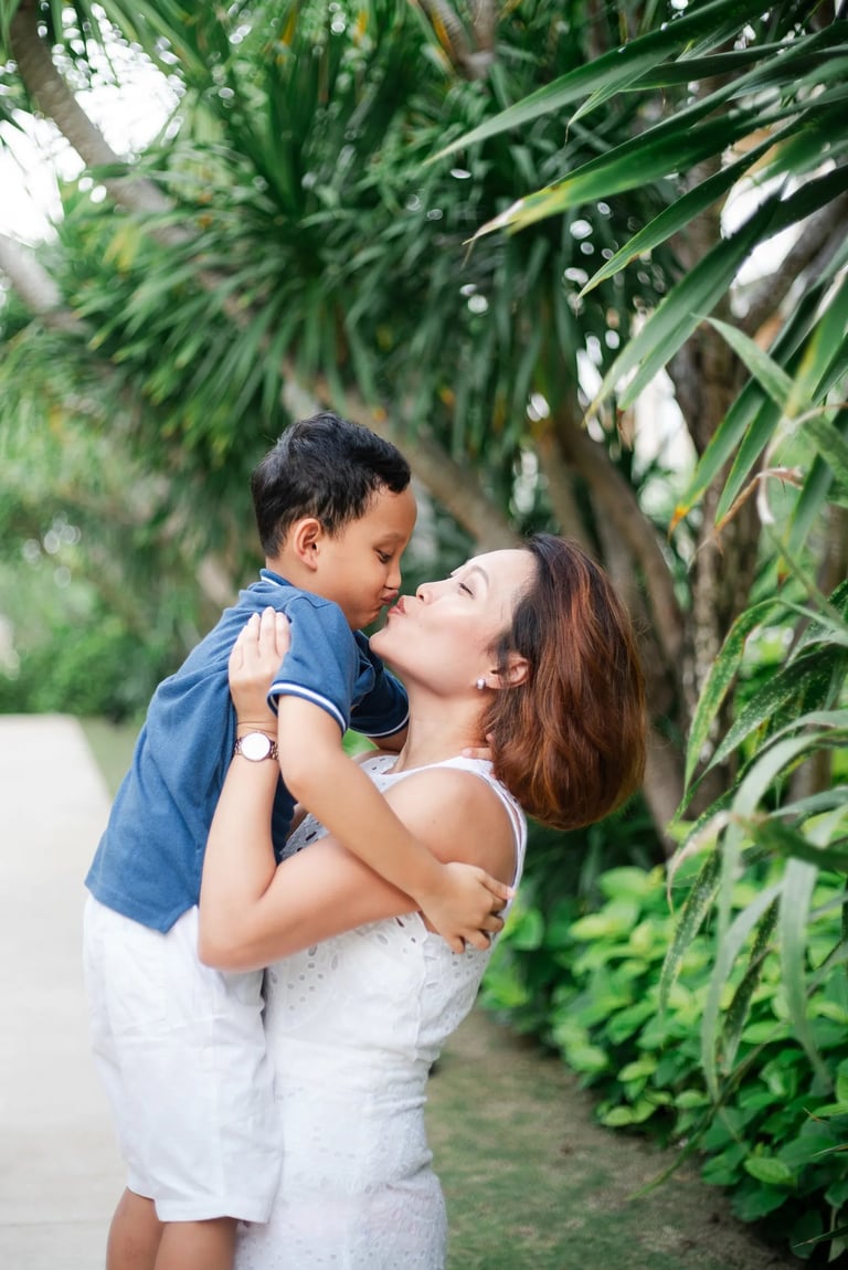Parents embracing with child during garden session at The Mulia Nusa Dua Bali