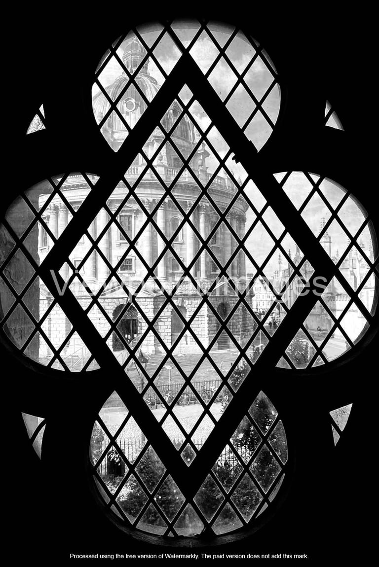 Black and white view of the Radcliffe Camera in Oxford through a gothic quatrefoil window.