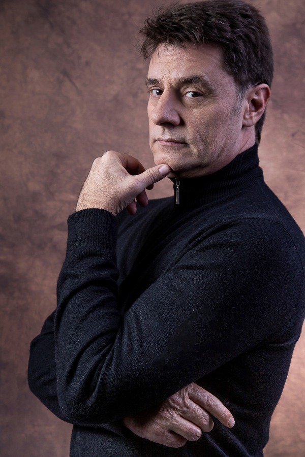 ator em pose reflexiva posando em estúdio vestindo camisa preta