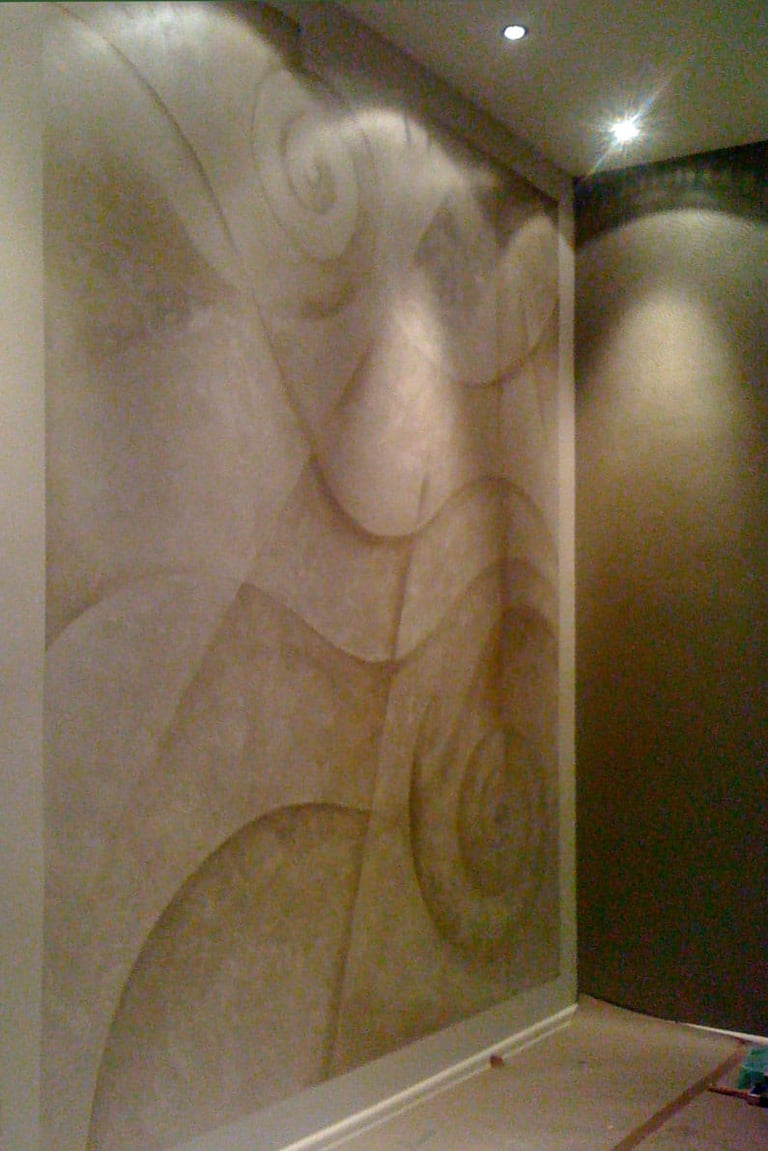 A room with abstract mural in silver paint featuring lines and wavy curves.