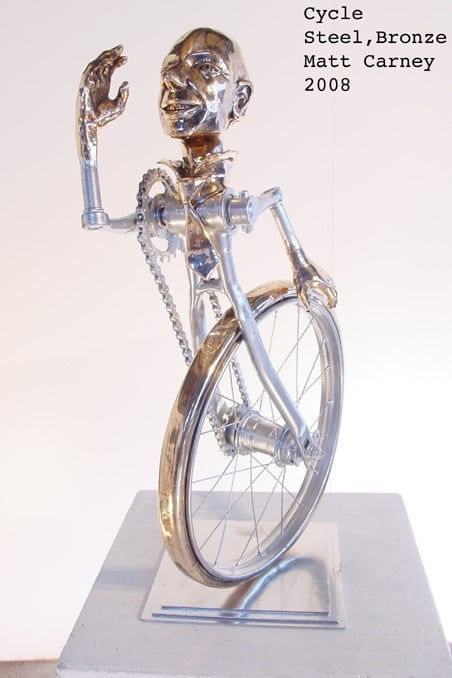 a silver and bronze sculpture of a man as a bicycle