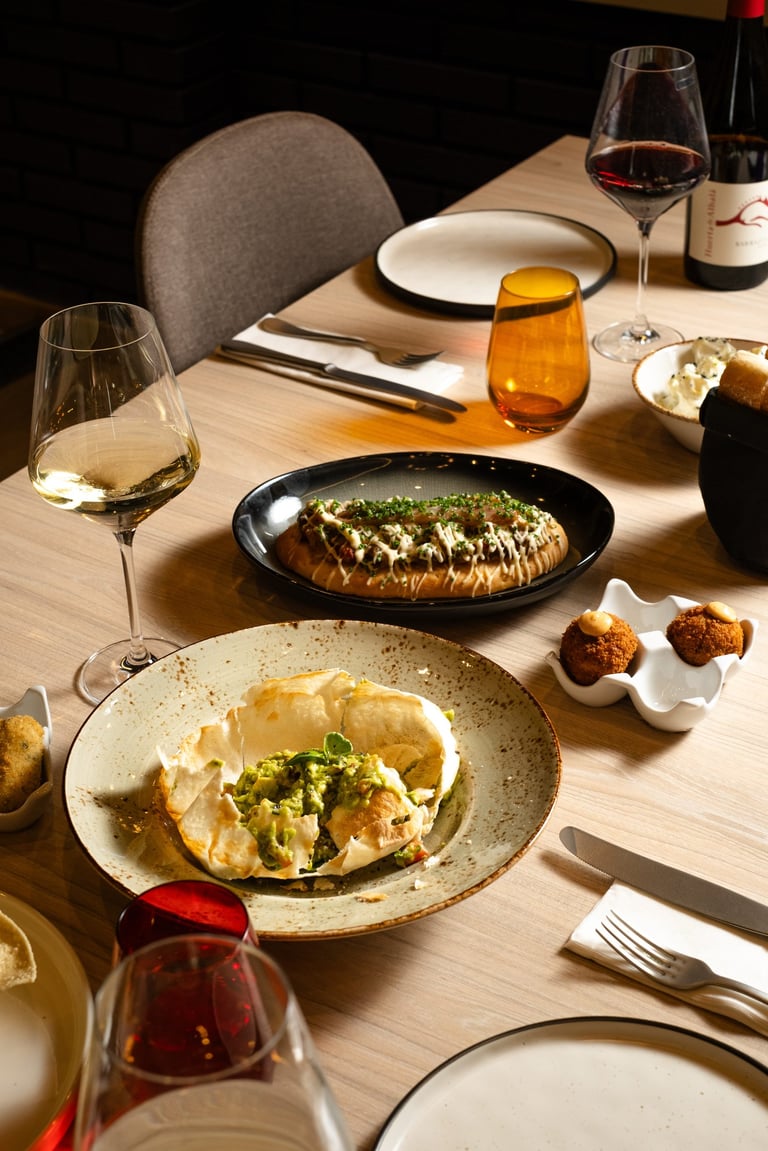 a table with plates of food and wine glasses