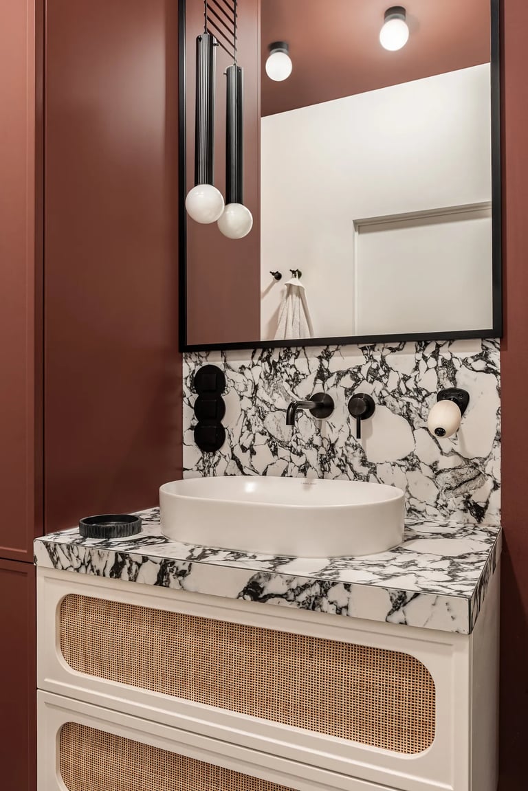 Fotografia detalu: marmur, rattan i armatura w łazience vintage.