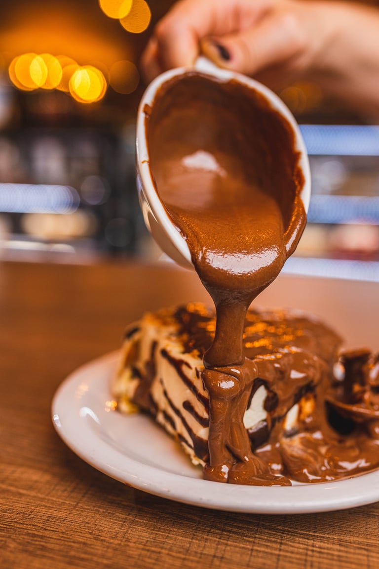 a person holding a cup of coffee and a piece of cake