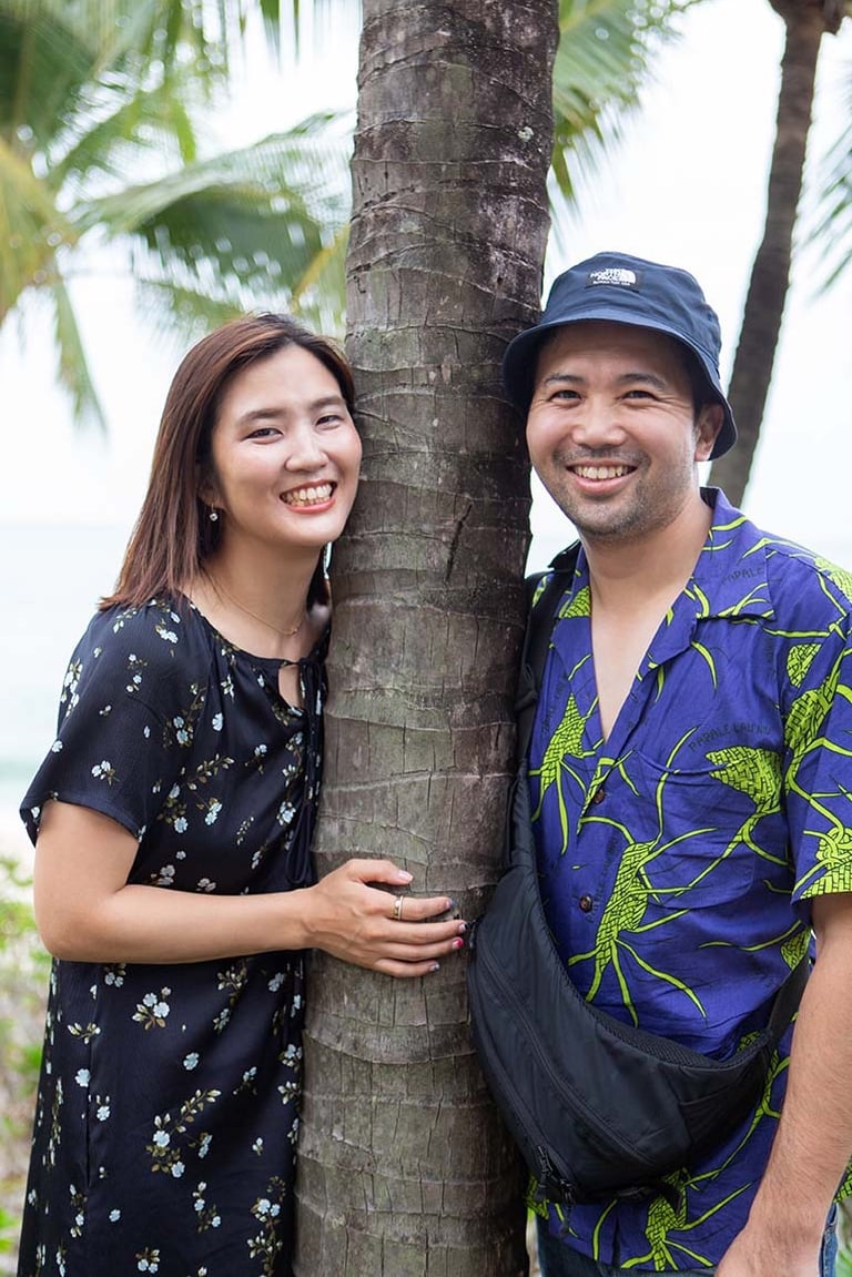 Couple smiling beside palm tree near Khem Beach