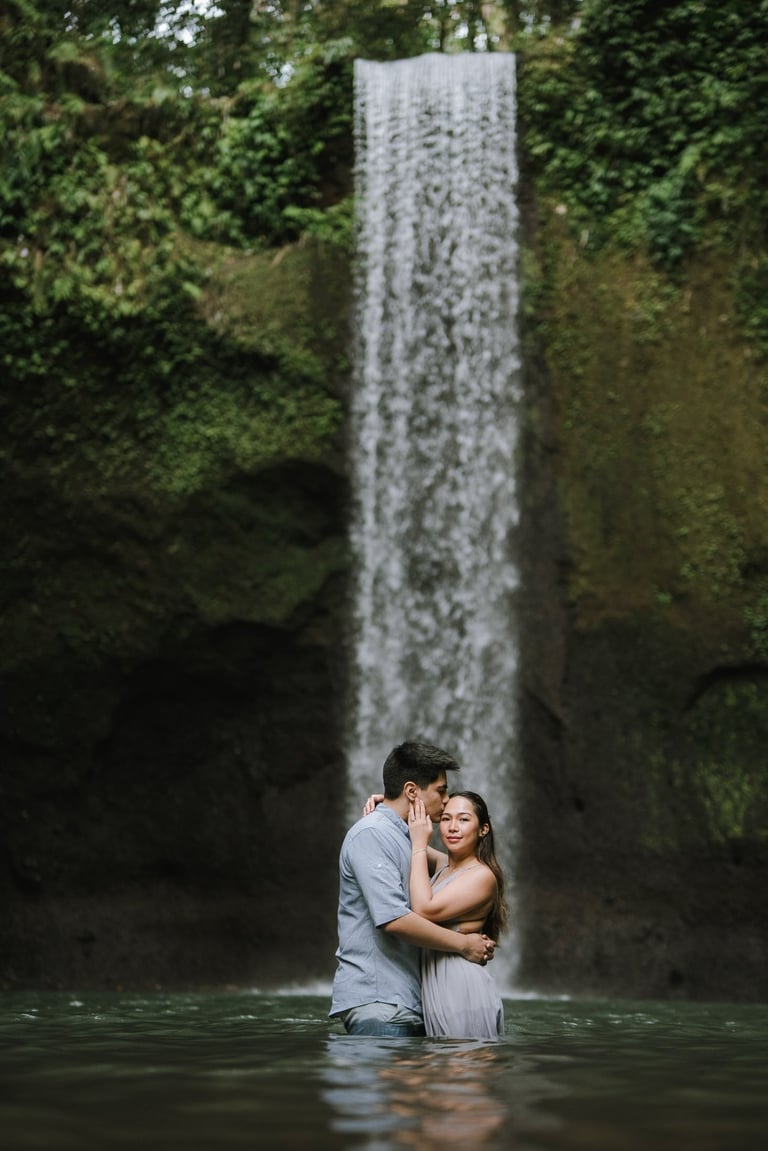 Intimate couple under waterfall at Tibumana Waterfall Bangli Bali