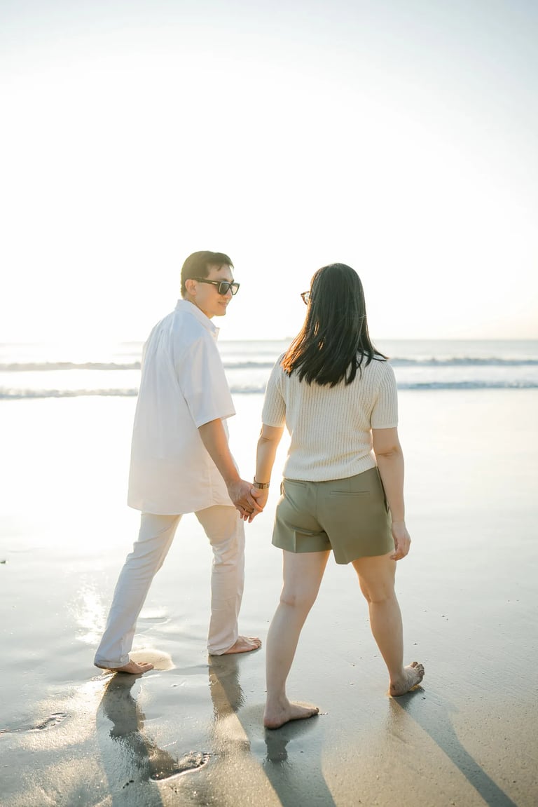 Family walking hand in hand on the beach at InterContinental Bali Resort during sunset