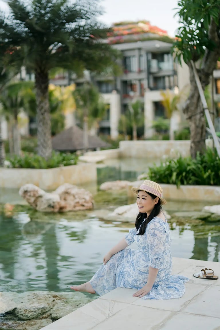 Woman standing beside the lagoon during a portrait session at The Apurva Kempinski Bali