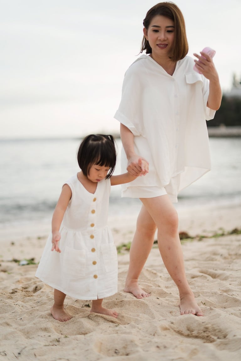 Mother walking with daughter along the beach during a family photography session at The Mulia Nusa Dua Bali