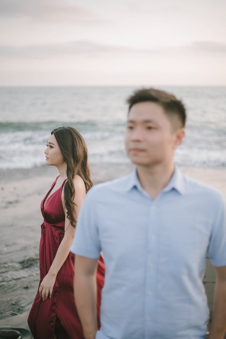 Intimate couple walking along the beach at sunset in Pantai Nyanyi Bali.
