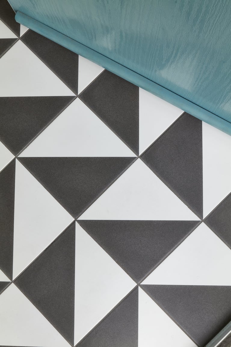 black and white geometric floor tile with a blue front door