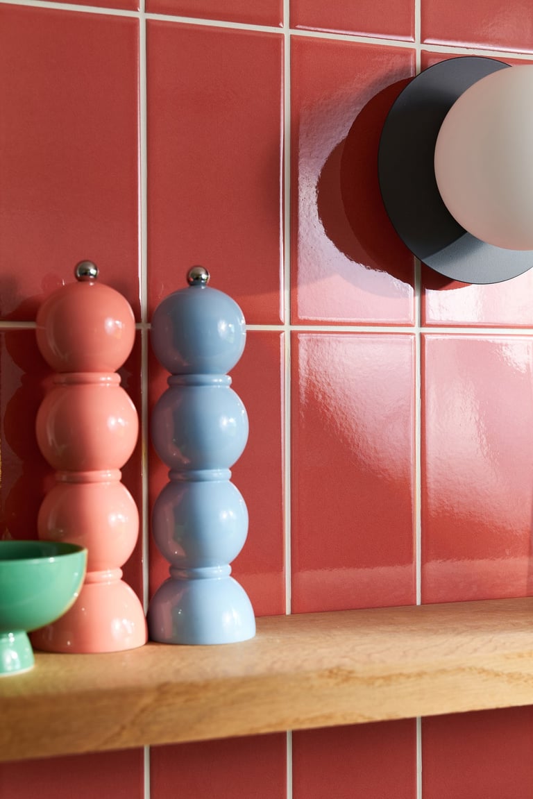 Glossy coral wall tiles with white grout in a modern kitchen splashback, featuring pastel pink 