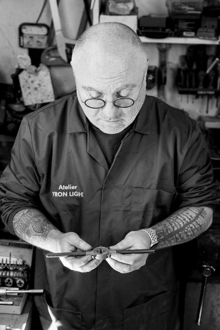 Artisan YronLight dans son atelier tenant une pièce de lampe à la main
