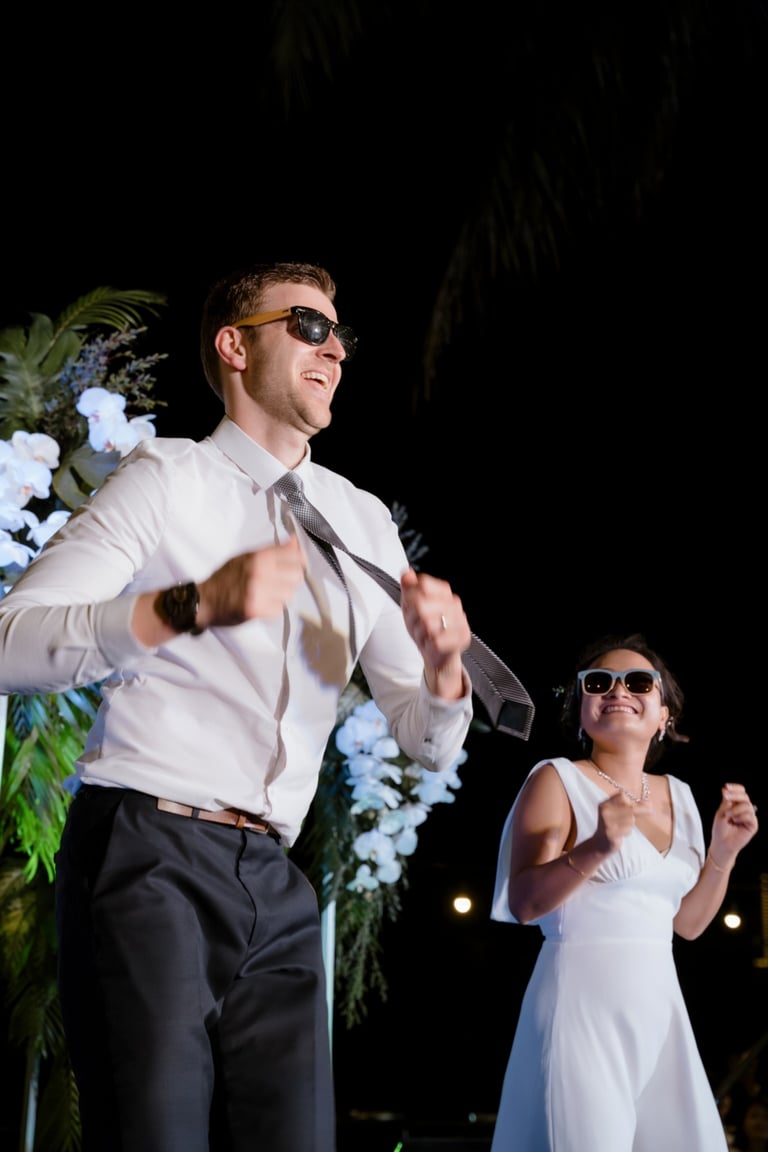 a man and woman in white dress clothes and sunglasses