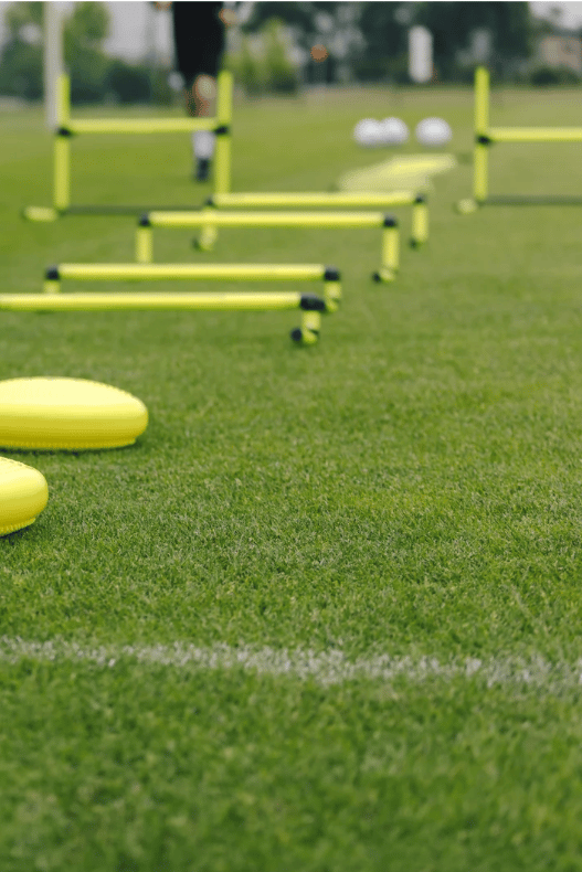 alt="Yellow agility hurdles and cones arranged on a grassy soccer field for Crestline FC"