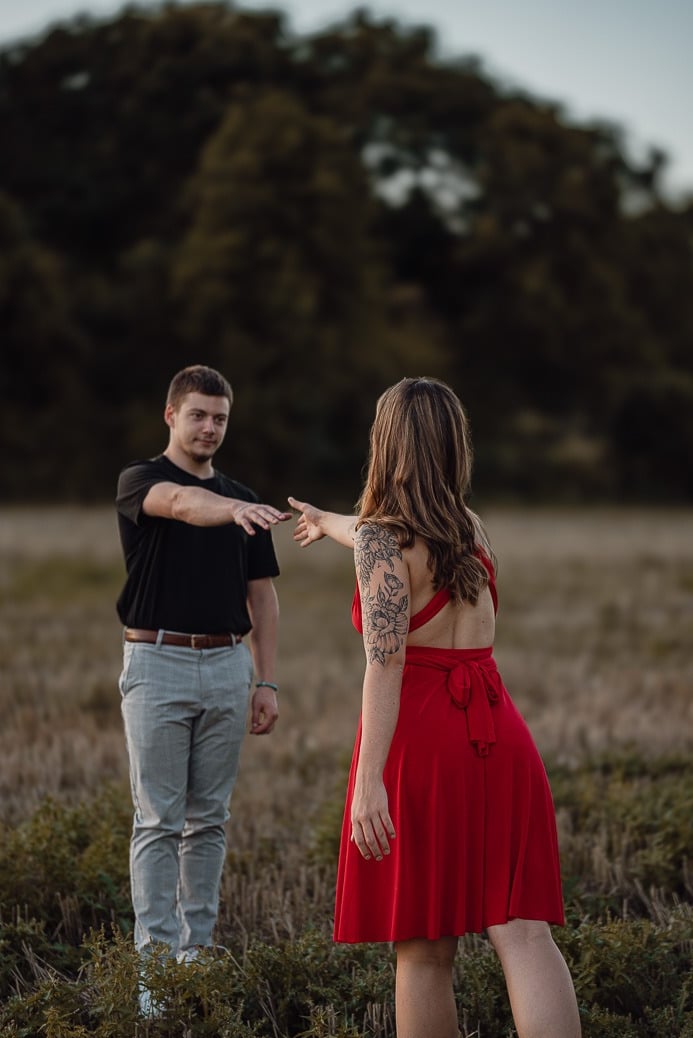 portrait de couple se tendant la main dans un champs