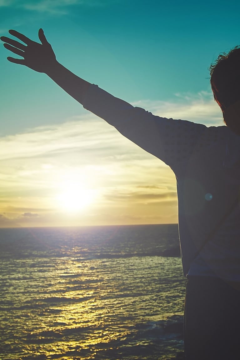 homme levant les bras face au soleil. nouveau depart grace au magnetisme