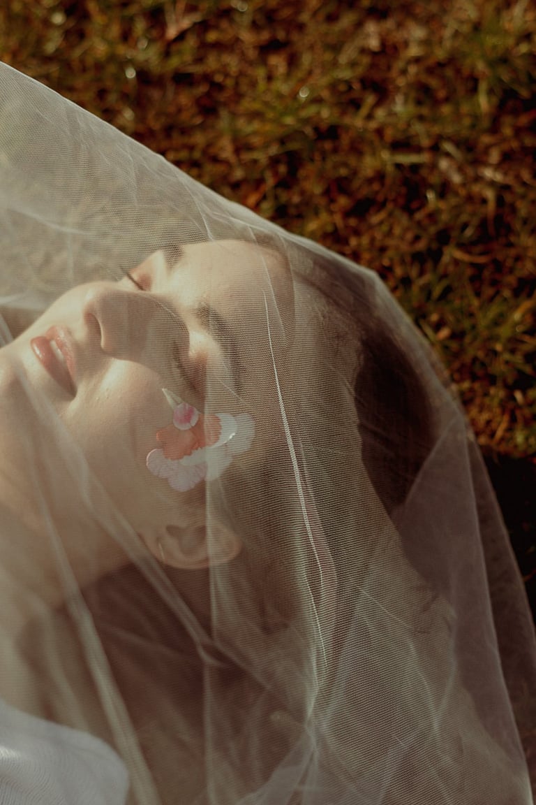 portrait rapproché d'un visage féminin maquillé recouvert d'un voile en tulle transparent