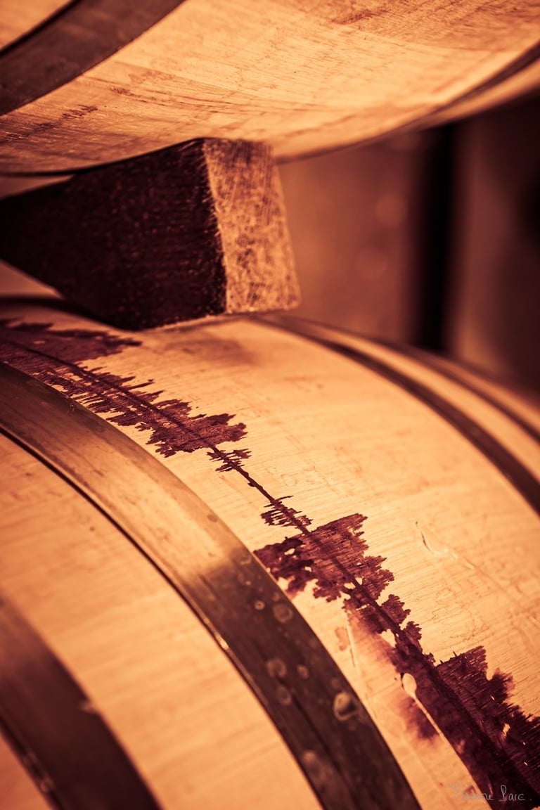 Détail d’un fût marqué par une coulée de vin rouge sombre, cicatrice symbolique.