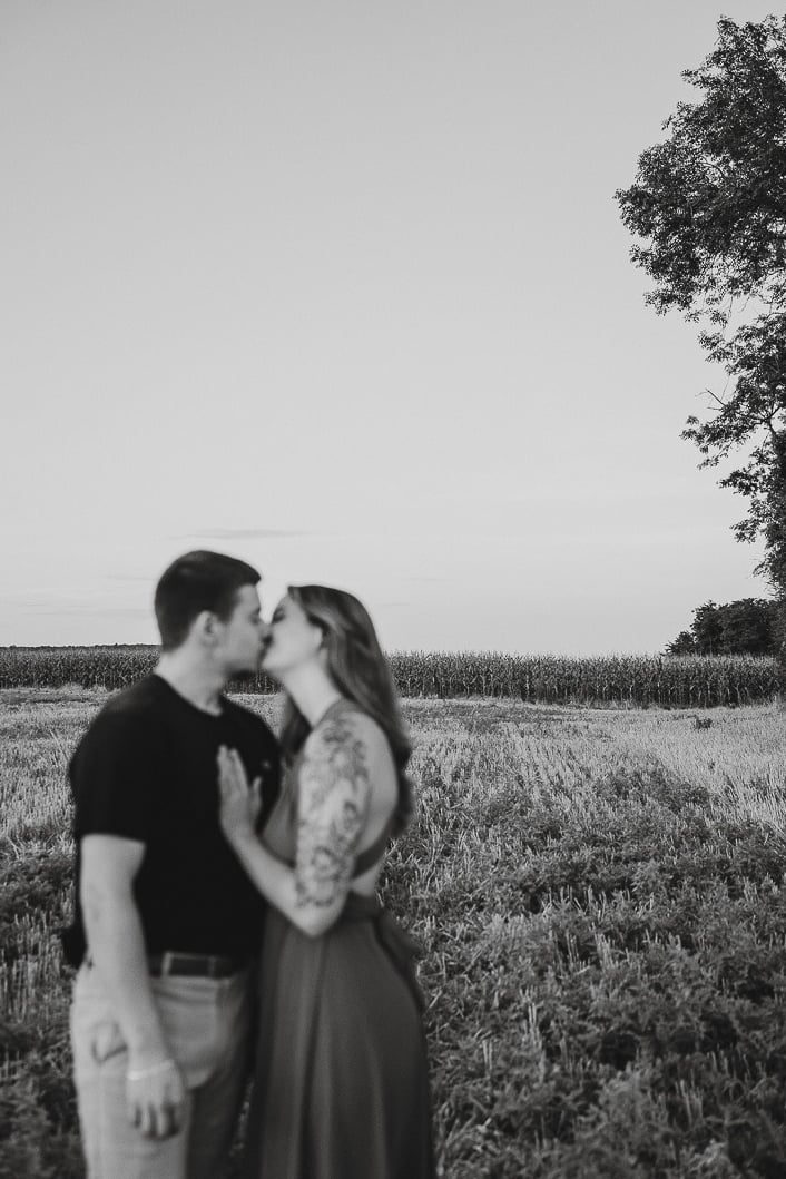 plan large d'une couple en noir et blanc qui s'embrasse premier plan flou paysage net