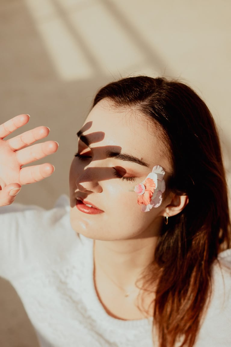 portrait féminin cachant son visage du soleil avec sa main