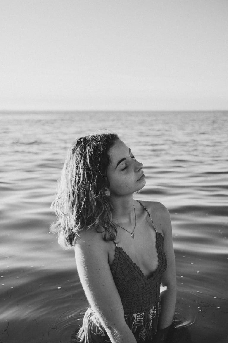 femme dans la mer jusqu'aux hanches fermant les yeux