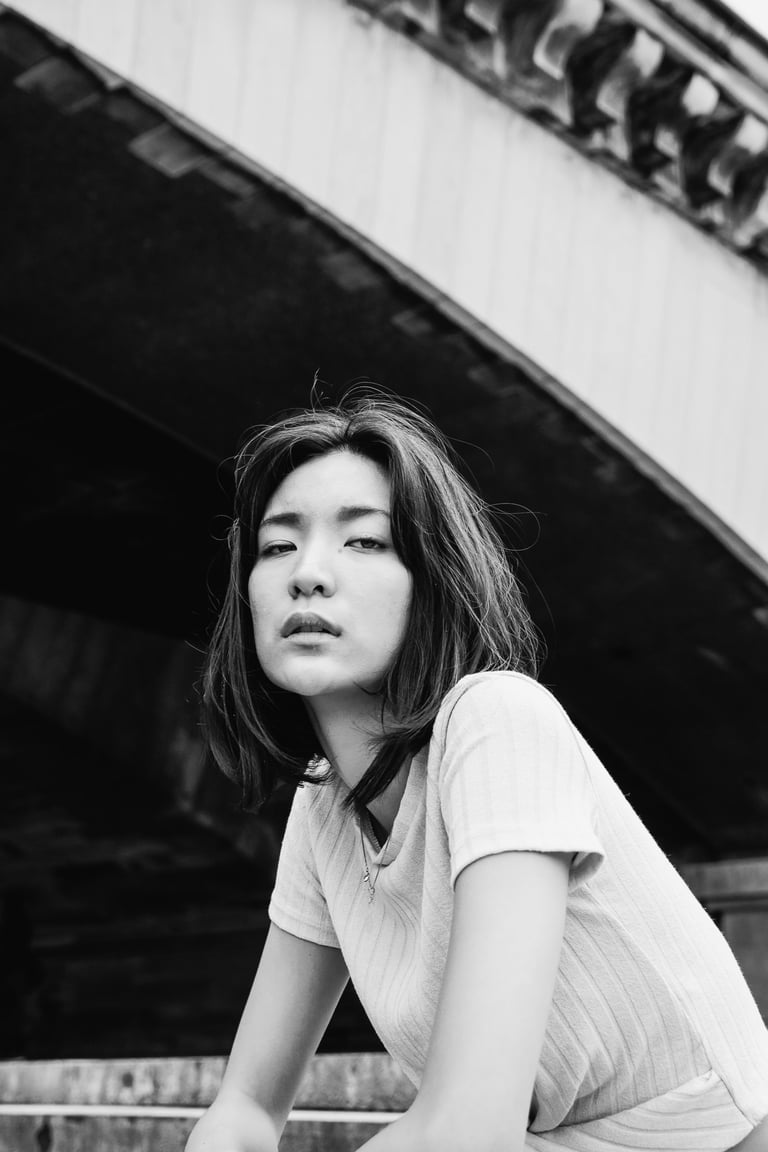 portrait féminin en noir et blanc regardant l'objectif en extérieur