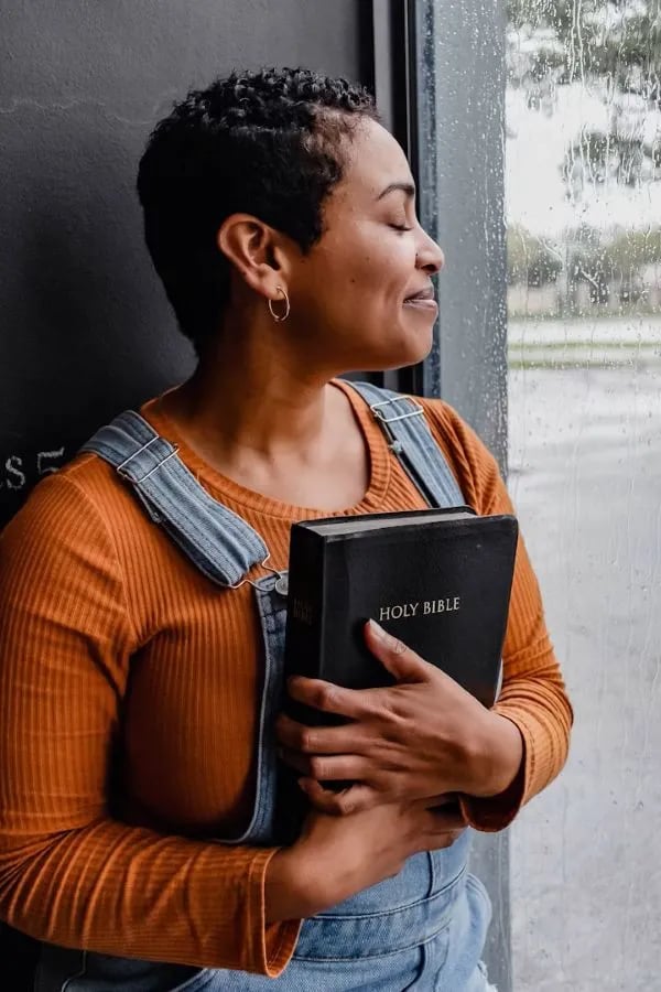 woman holding smiling from bible answers she got from bible