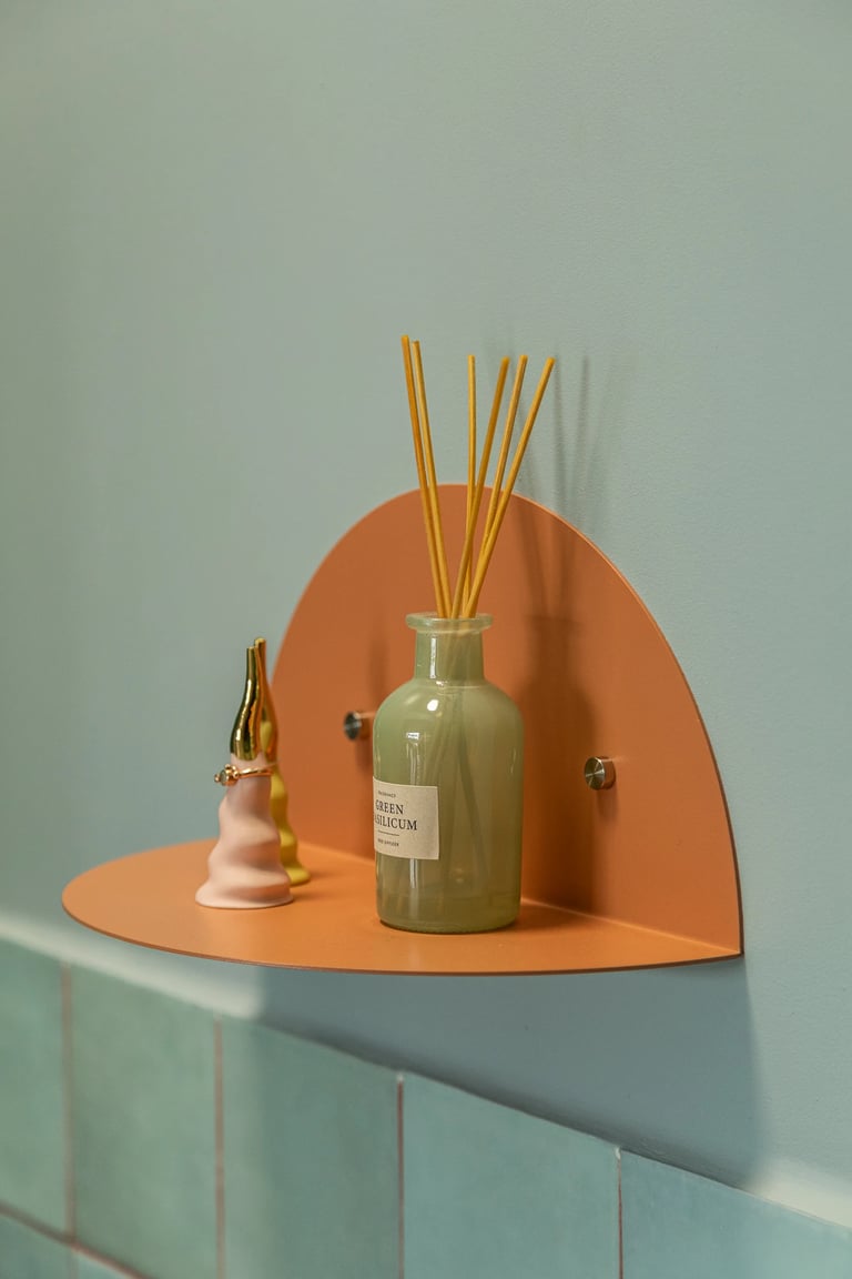 Stylizacja łazienki: dekoracje na półce i pastelowe kolory.