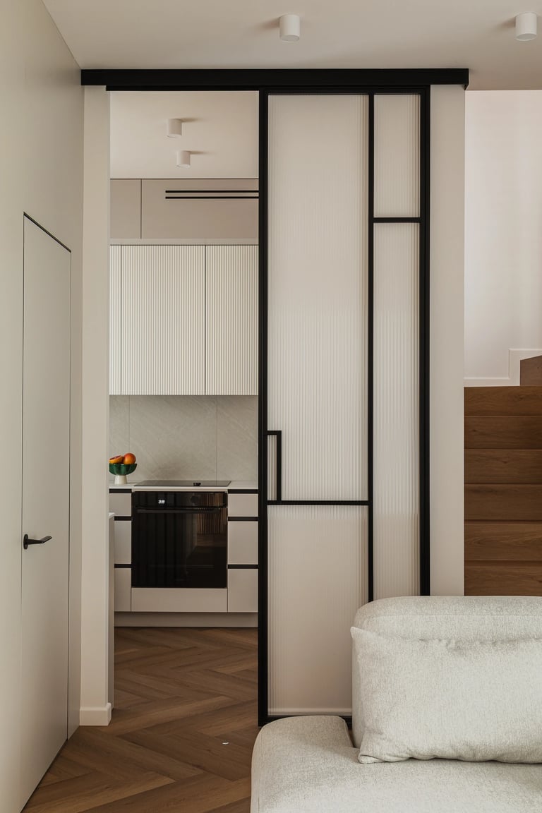 Czarne drzwi przesuwne ze szkłem ryflowanym, widok na kuchnię.