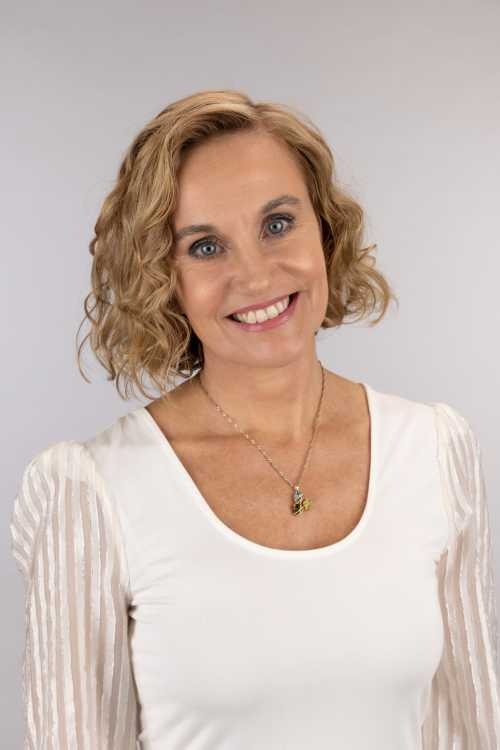 a woman with a necklace and a necklace with a flower, dori best