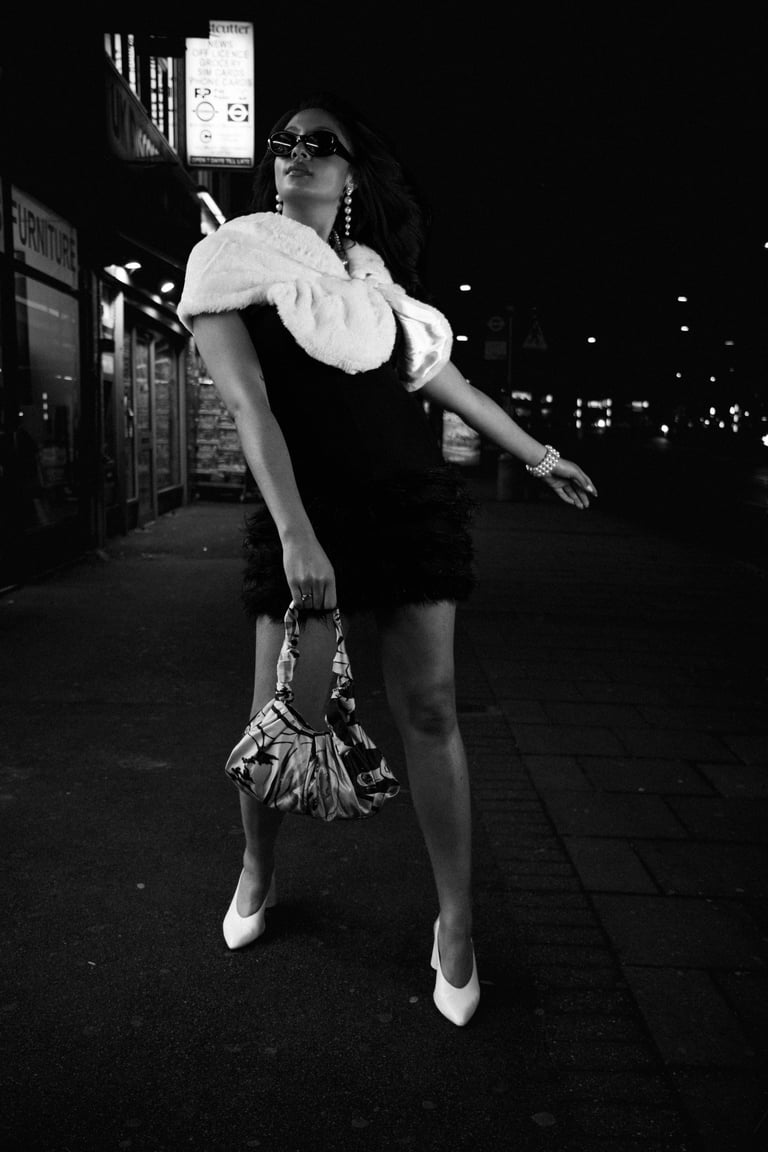 Black and white night street portrait of a woman in an urban setting