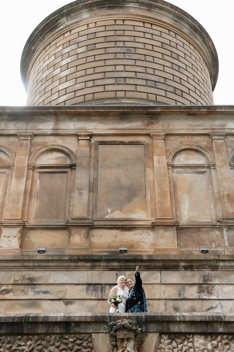a bride and groom standing on a balcony