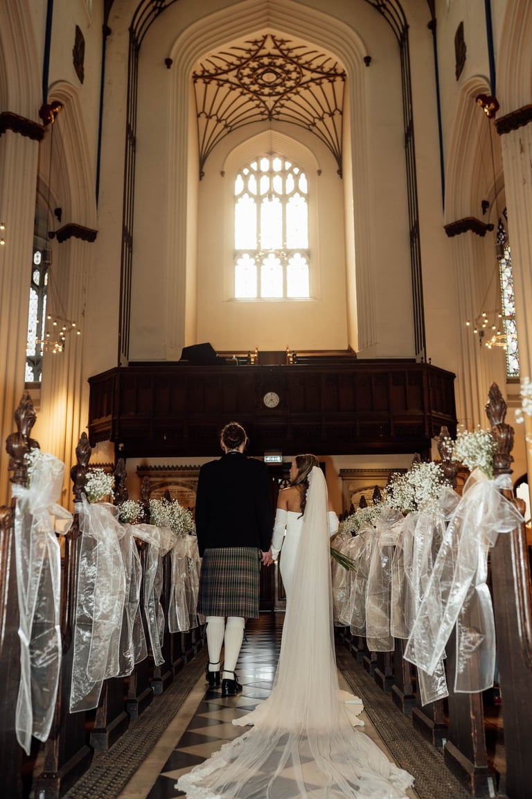 a bride and groom are standing in a church