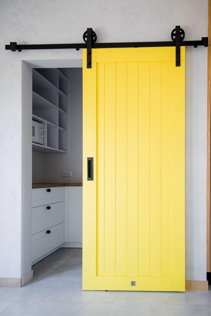 Drzwi przesuwne w kolorze żółtym, oddzielające kuchnię od pozostałej części mieszkania