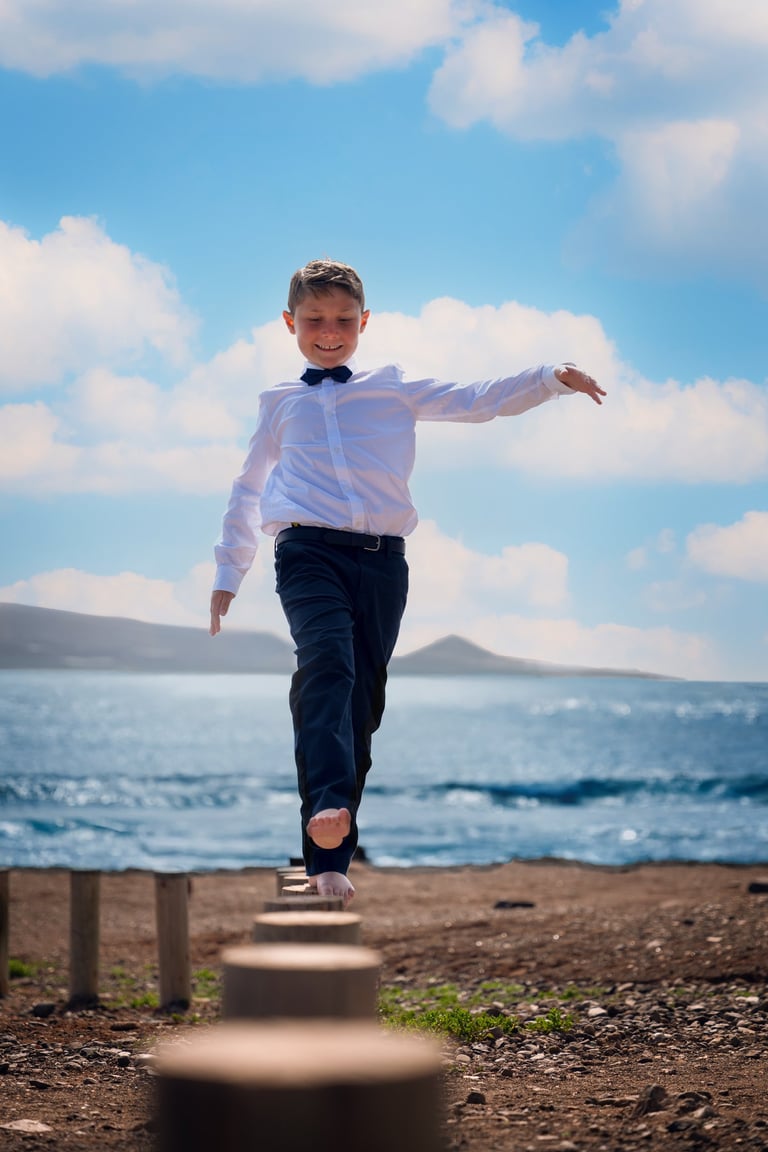 a young boy is walking on a wooden platform