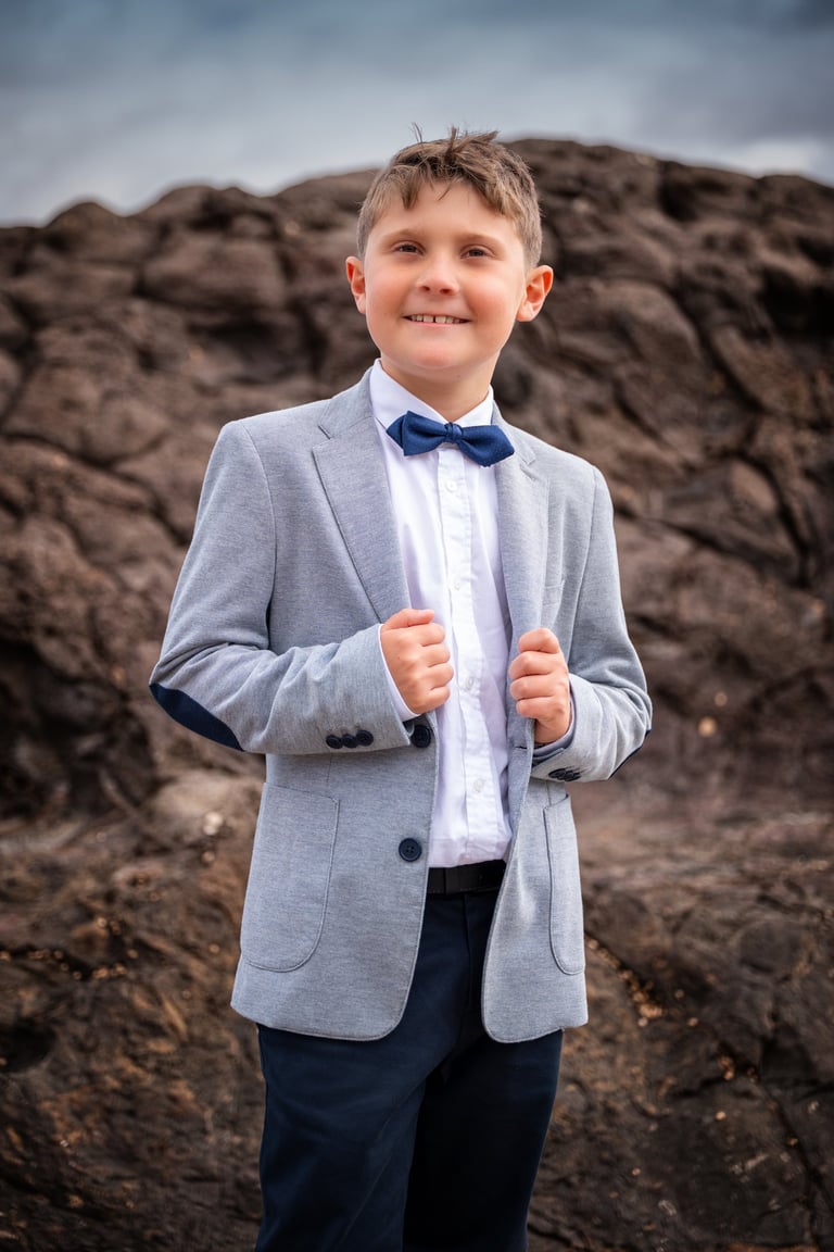 a young boy in a suit and bow tie