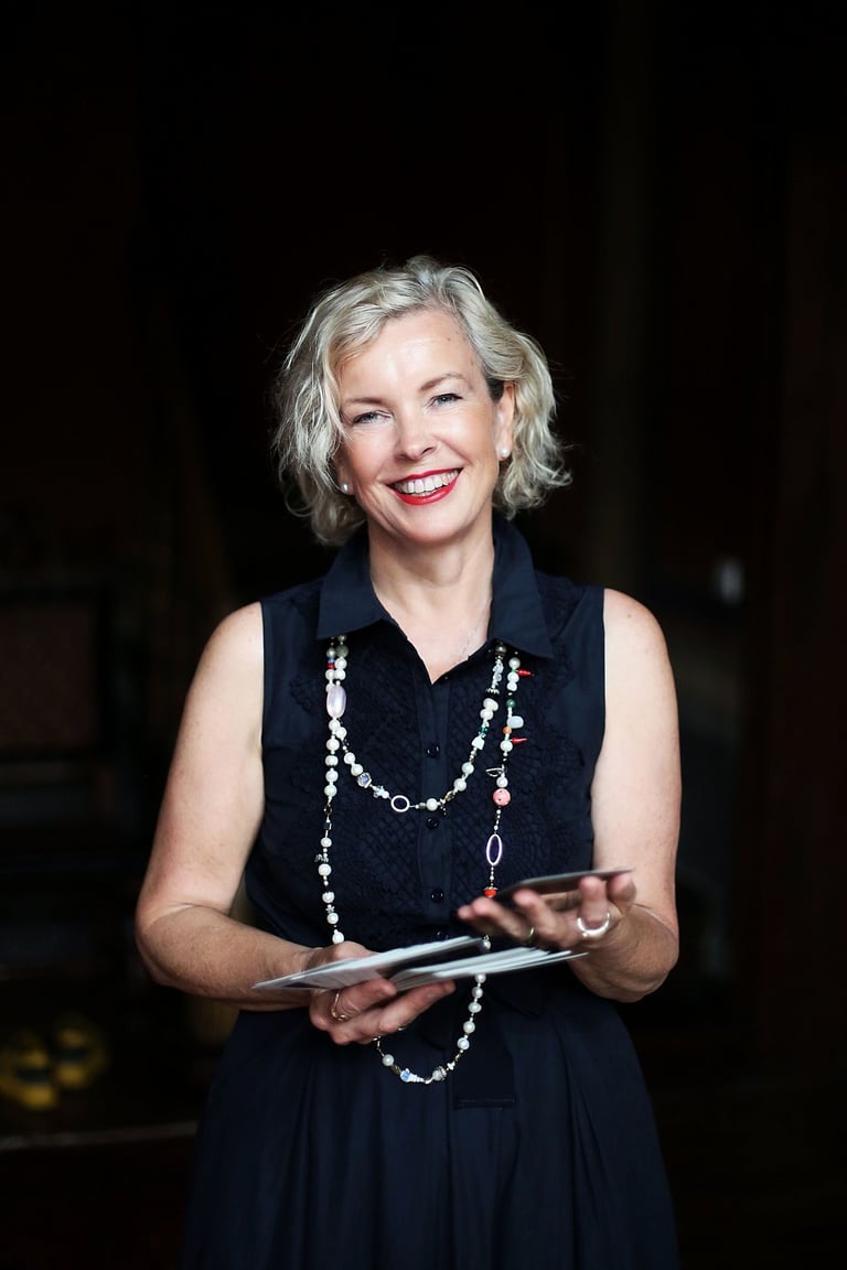 a woman in a black dress and pearls necklaces