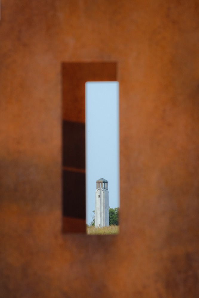 A lighthouse shot through an bronze urban sculpture. Framing looks cool.