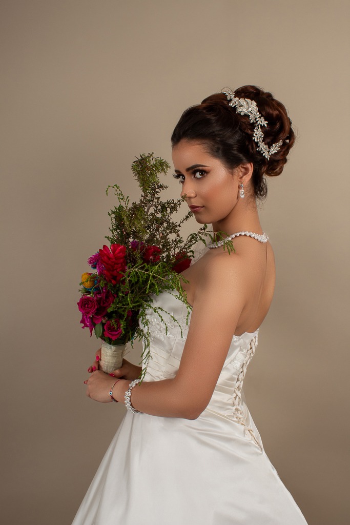 Retrato detallado de novia luciendo vestido de encaje en estudio.