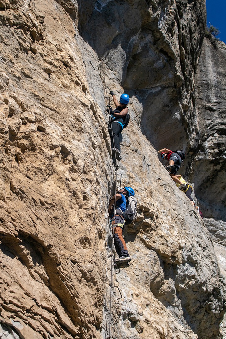 personas escalando una via ferrata