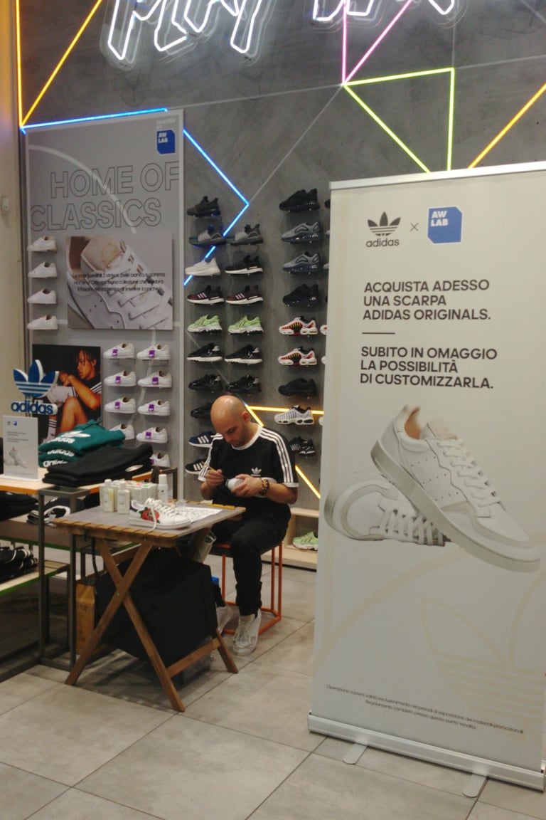 a man sitting at a table customizing shoes