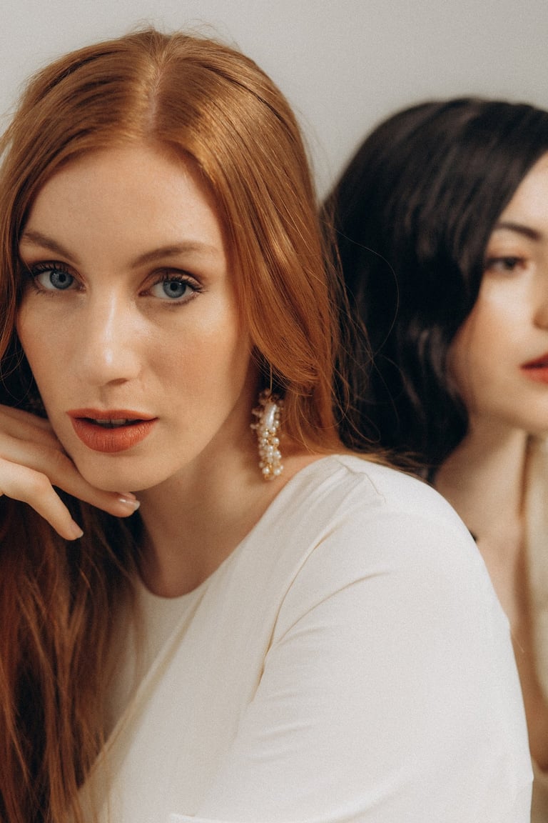 two women with long hair and earrings on their heads