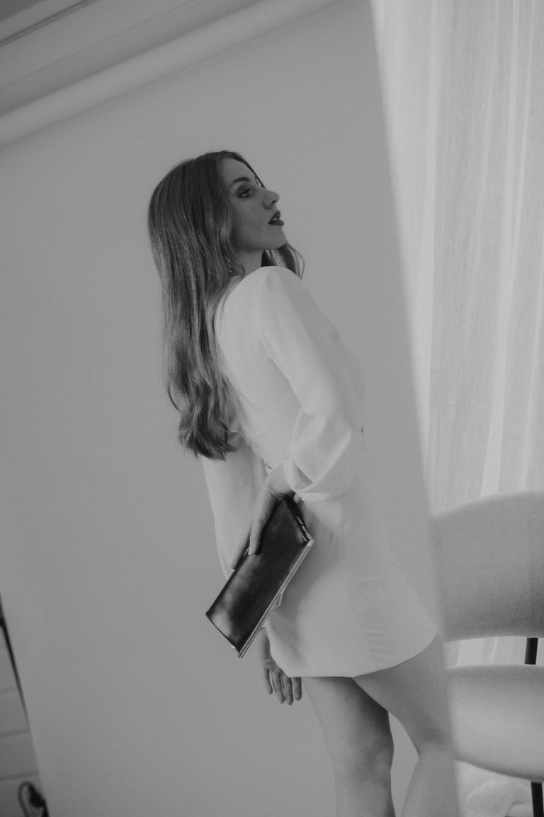 a woman in a white dress and a black purse