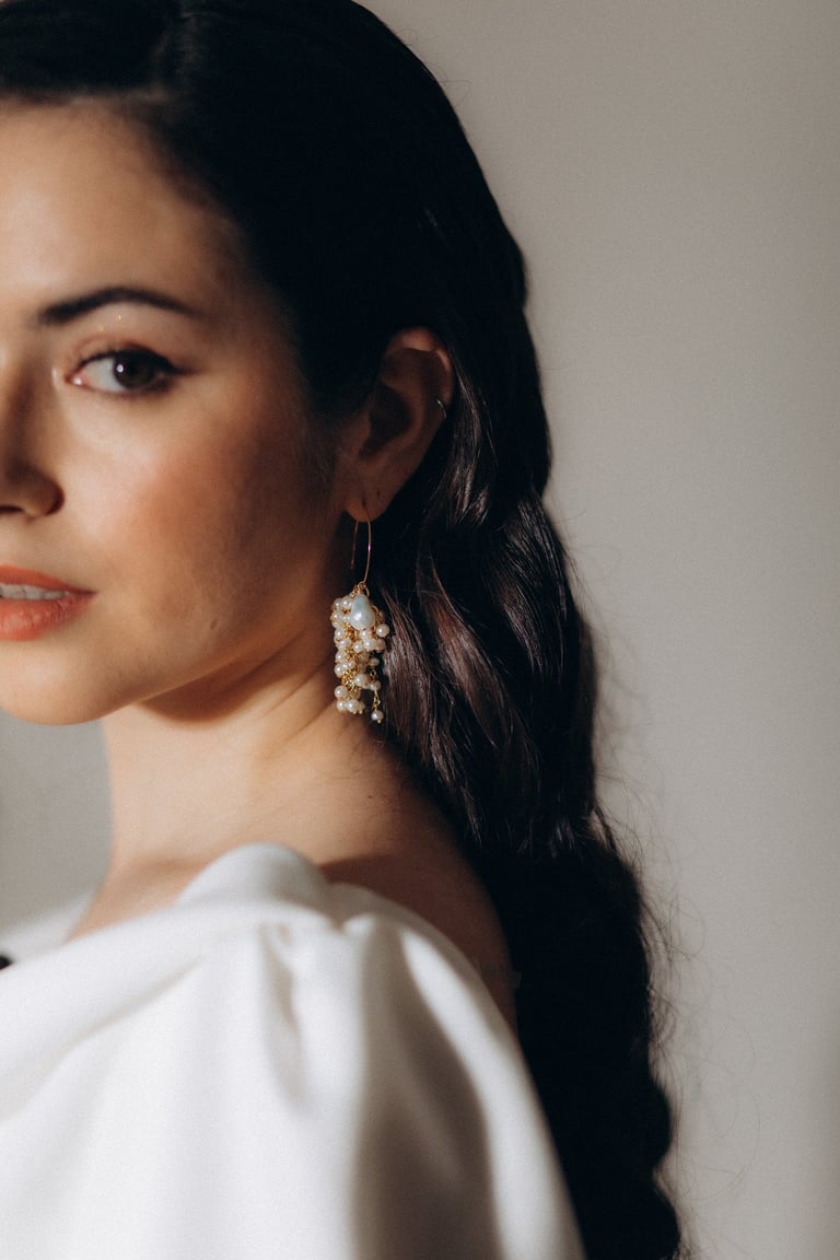 a woman with long hair and earrings on her head