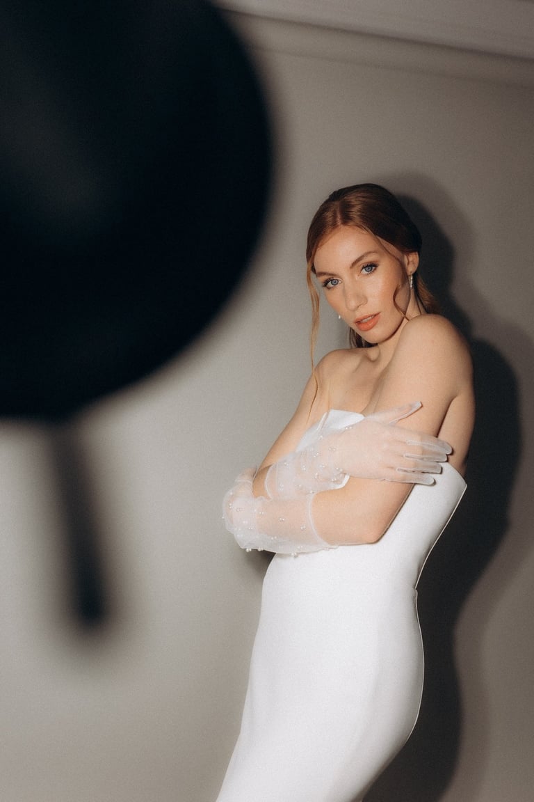 a woman in a white dress with a veil on her shoulder